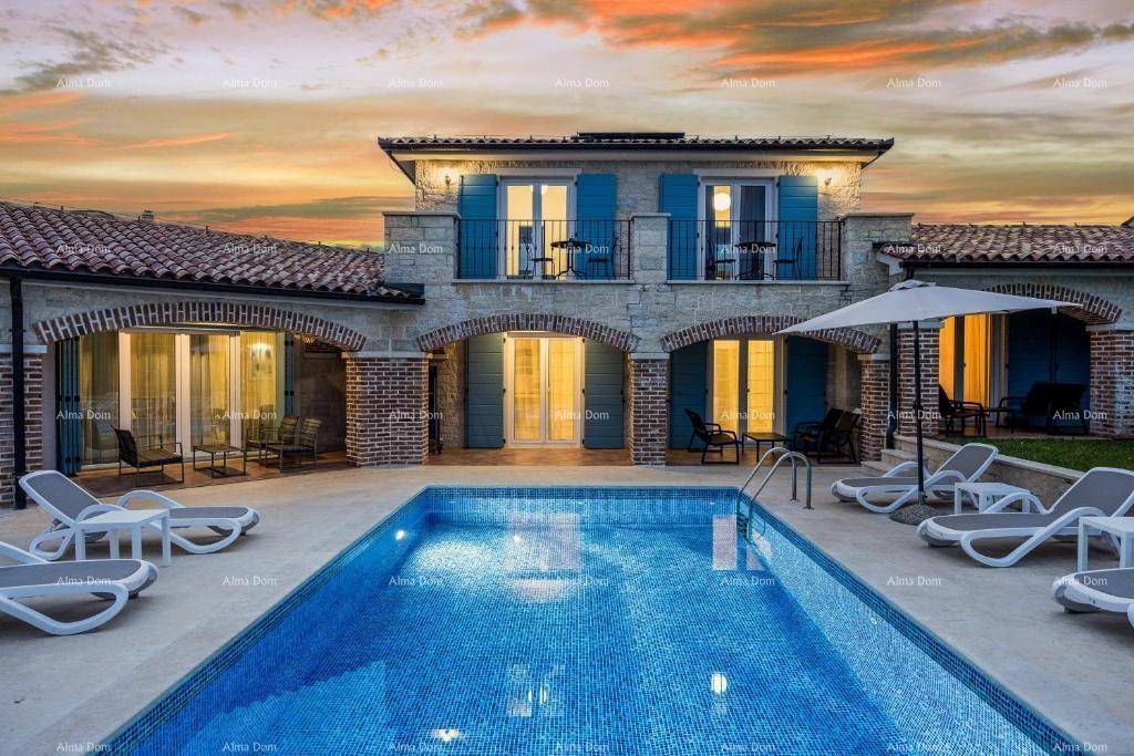 Villa mit beleuchtetem Poolbereich bei Sonnenuntergang, umgeben von mediterraner Architektur.