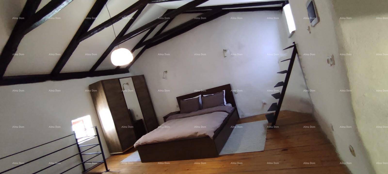 Gemütliches Schlafzimmer mit Holzbalken, Holzboden, Bett und Kleiderschrank im Dachgeschoss.
