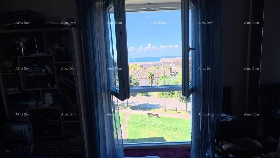 Schlafzimmer mit weitem Blick auf das Meer und die grüne Umgebung durch das Fenster.
