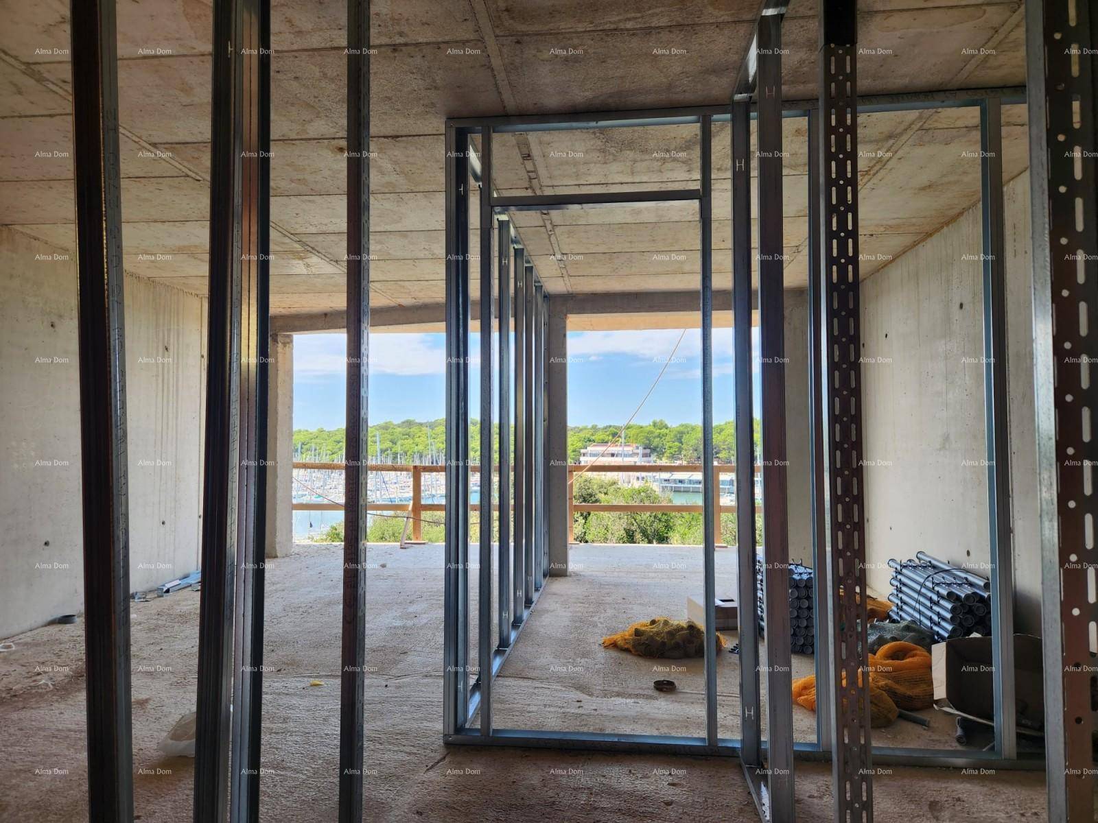 Rohbau-Innenraum mit Metallständerwerk für Wände und weitem Blick auf den Yachthafen und die Natur.