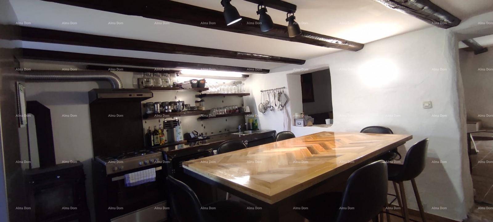 Geräumige Küche mit langem Holztisch, schwarzen Stühlen und sichtbaren Deckenbalken.