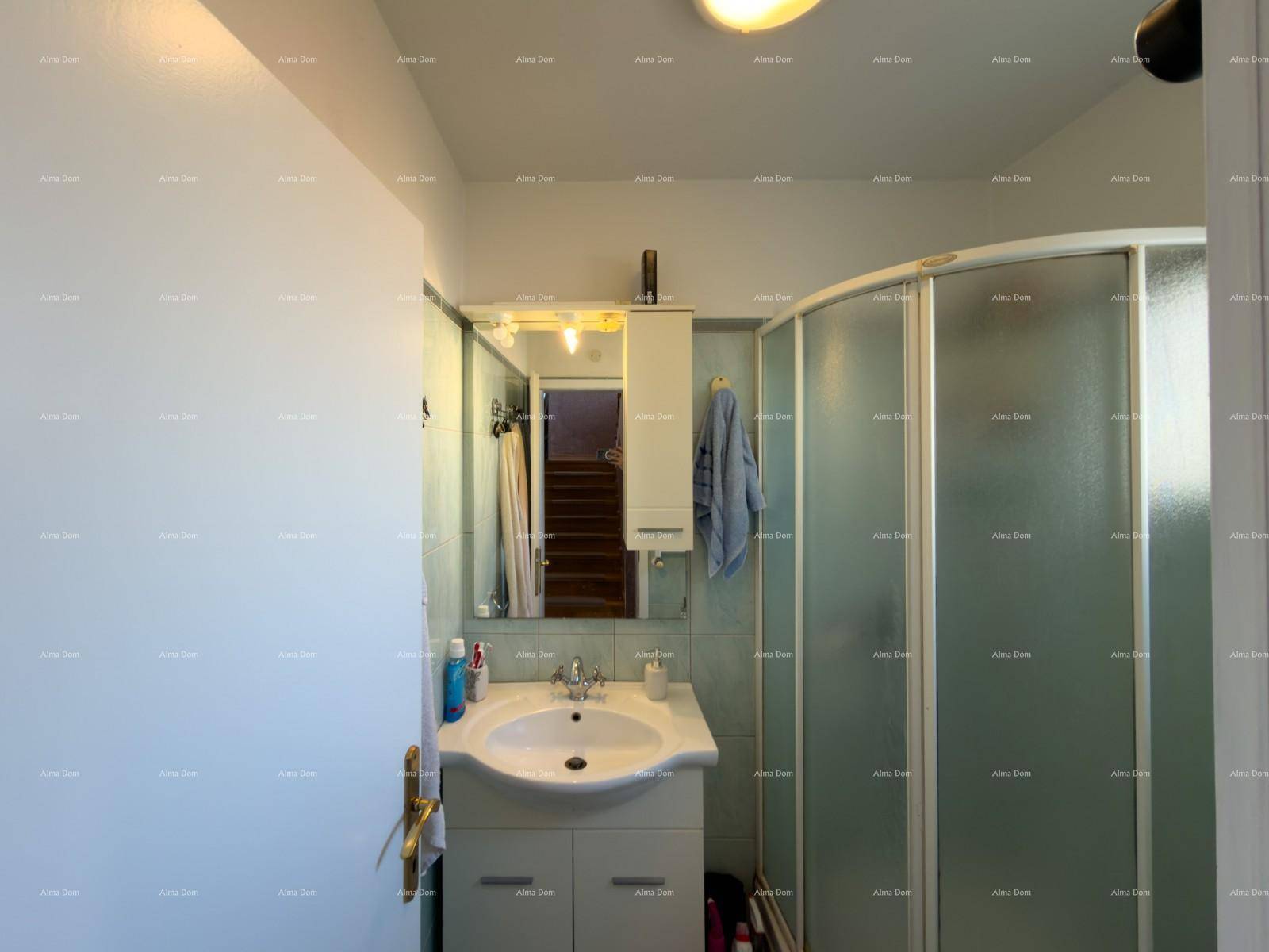 Funktionales Badezimmer mit Duschkabine, Waschbecken und Spiegelschrank.