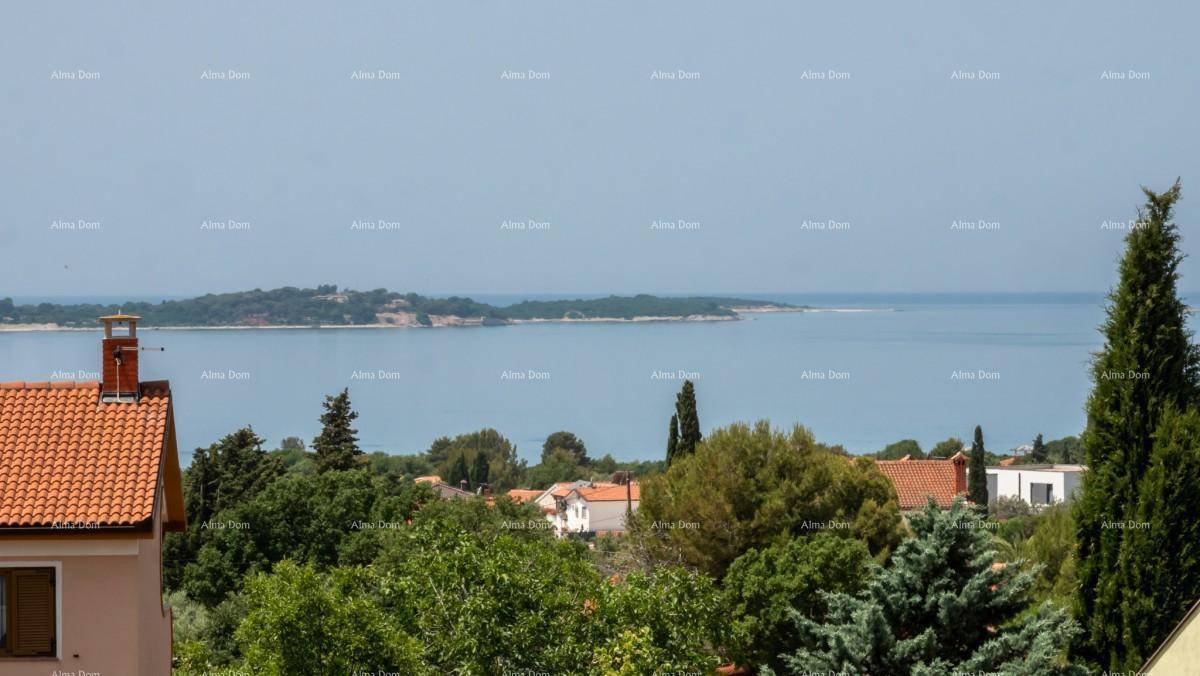Panoramablick auf das Meer und die Küstenlinie, umgeben von üppiger grüner Vegetation.