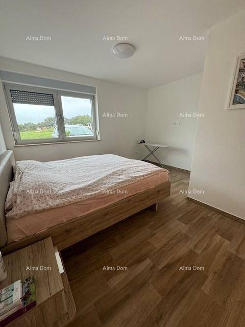 Gemütliches Schlafzimmer mit Holzfußboden, einem Doppelbett und Blick nach draußen.