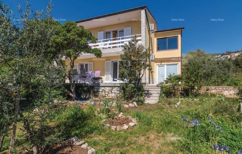 Seitenansicht des Hauses mit Gartenbereich, Terrasse und Blick auf die grüne Umgebung.