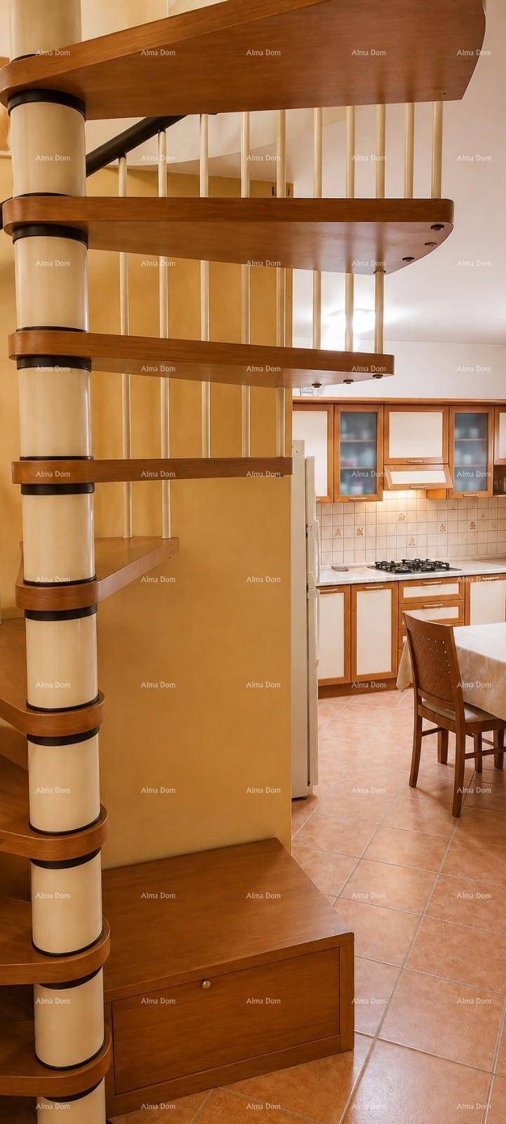 Elegante Holzwendeltreppe mit weißen Geländerstäben, die in den oberen Bereich führt.