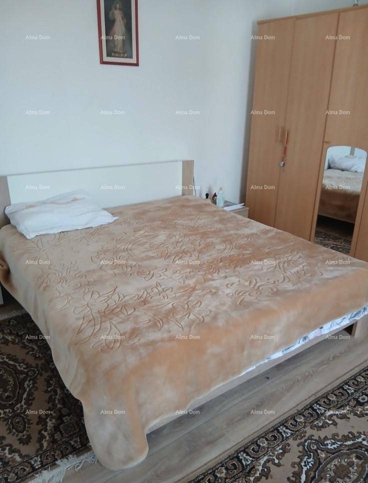 Schlafzimmer mit Doppelbett, Holzschrank und Teppich auf Laminatboden für gemütliche Nächte.