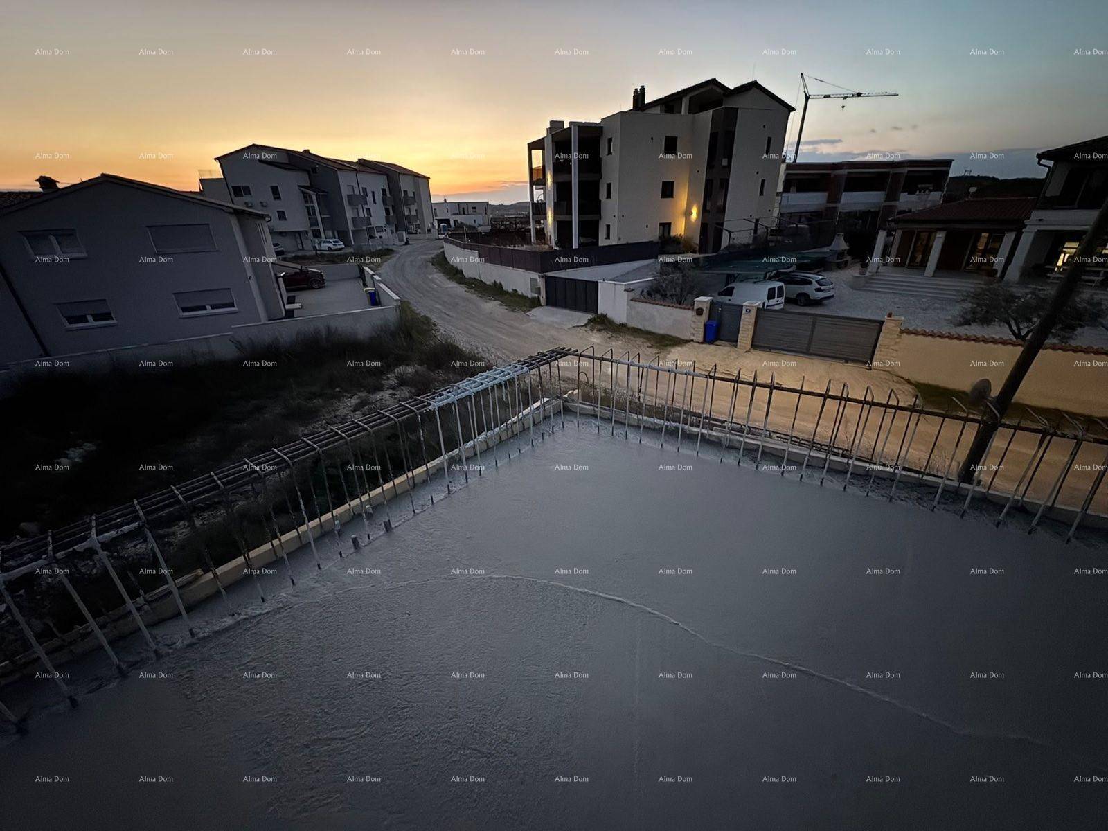 Baustelle mit Betonfläche und umliegenden Gebäuden bei Sonnenuntergang, mit Blick auf die Straße.