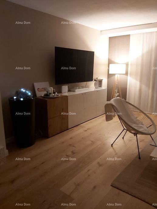Gemütliches Wohnzimmer mit Holzboden, großem Fernseher und indirekter Beleuchtung.