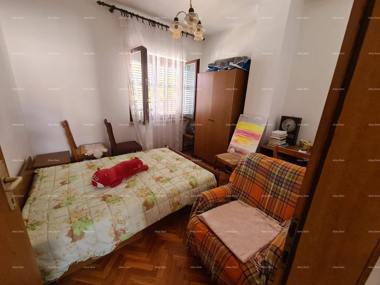 Gemütliches Schlafzimmer mit Holzboden, einem Bett und einem Sessel, bietet eine entspannte Atmosphäre.