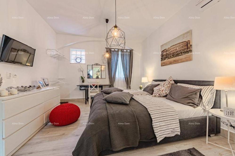 Schlafzimmer mit modernem Design, Holzboden und einem Schreibtischbereich neben dem Fenster.