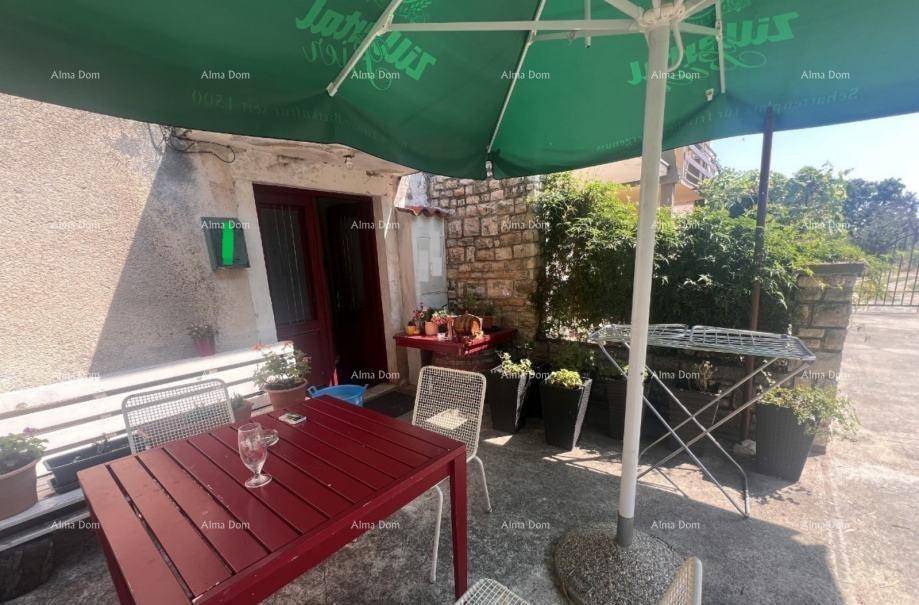 Gemütlicher Terrassenbereich mit rotem Tisch und Stühlen, ideal für Mahlzeiten im Freien.