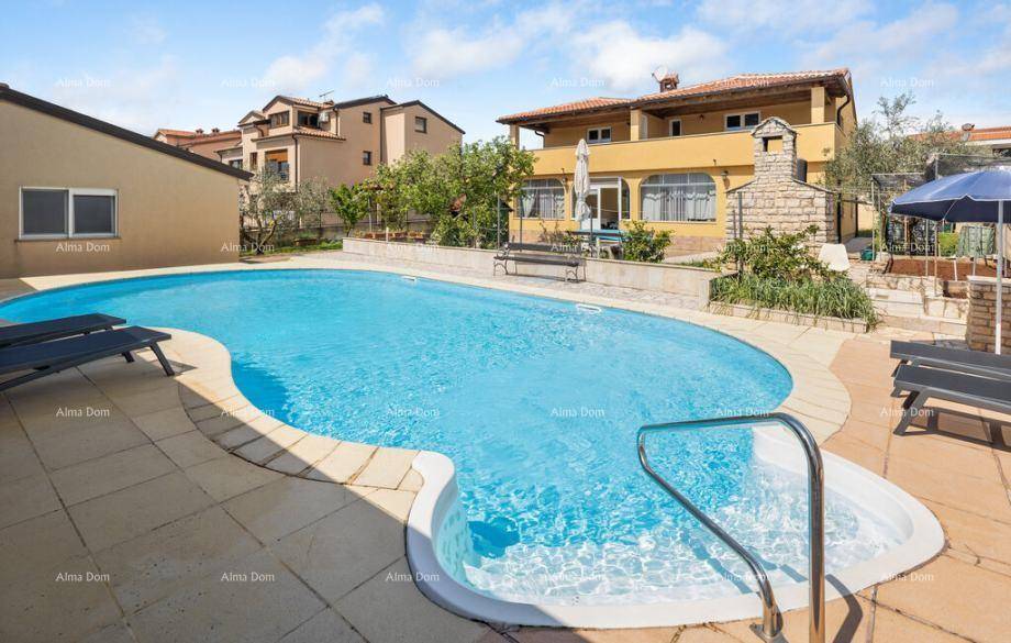 Großer Swimmingpool mit integriertem Whirlpool und angrenzendem Grillbereich vor dem Haus.