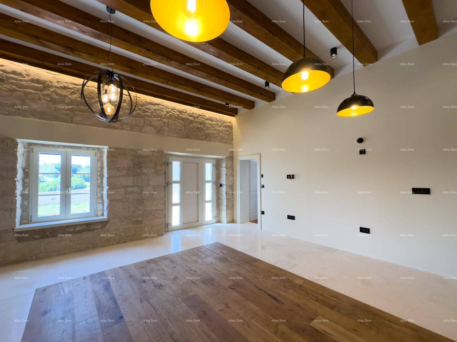 Wohnbereich mit rustikaler Steinwand, Holzbalkendecke und großen Fenstern für viel Licht.