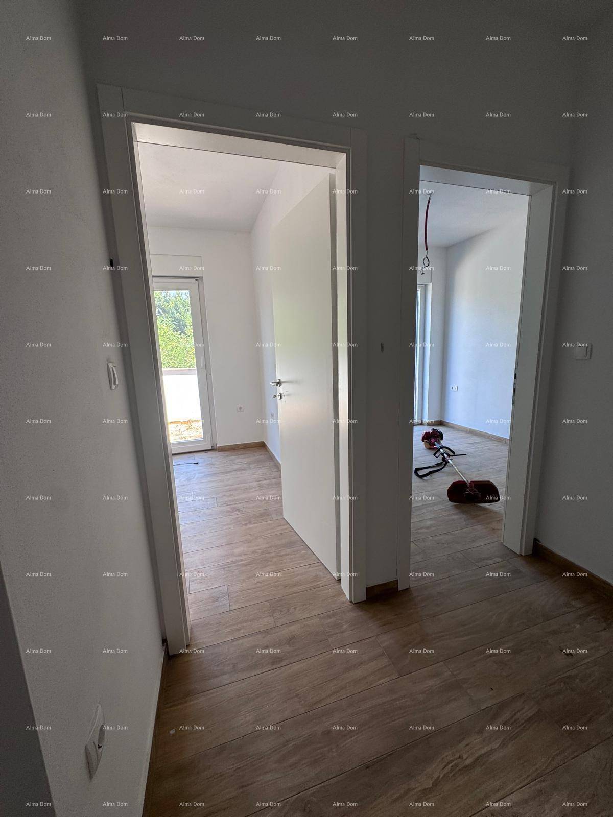Blick durch zwei offene Türen in separate Räume mit Holzboden und weißen Wänden.