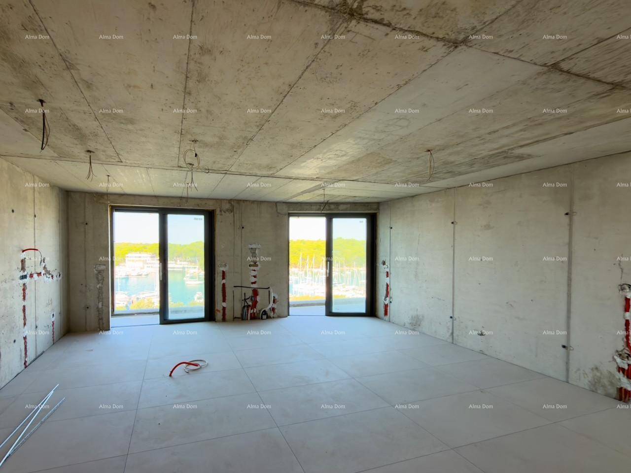 Geräumiger Wohnbereich im Rohbau mit Fliesenboden und weitem Blick auf den Yachthafen durch große Fenster.