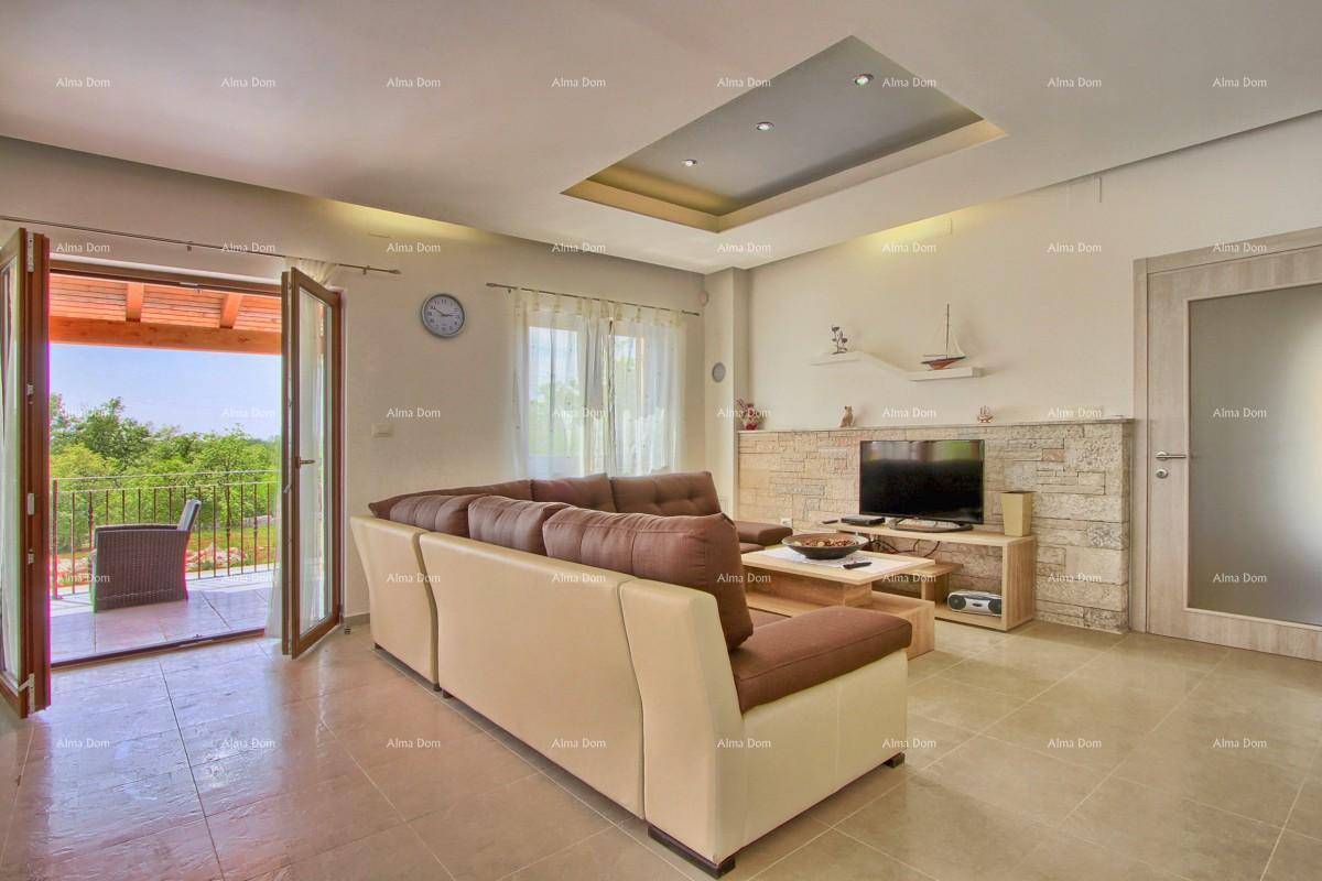 Helles Wohnzimmer mit beigem Ecksofa, Fernseher und direktem Zugang zur Terrasse.