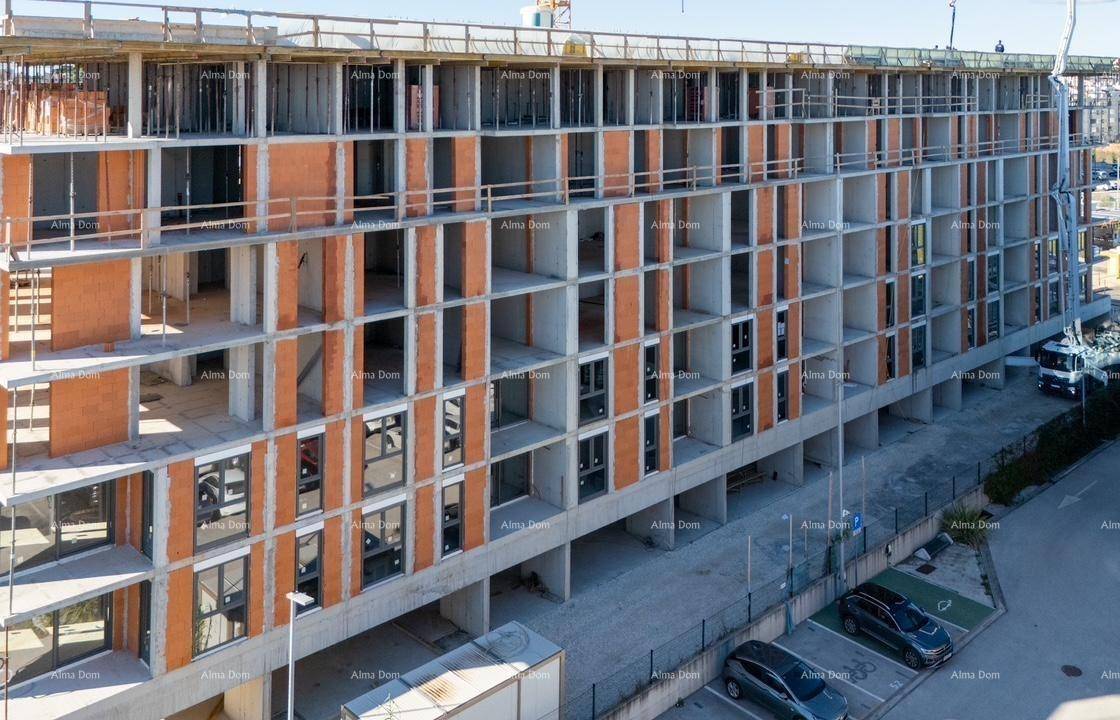 Detailansicht der Fassade des Rohbaus mit zahlreichen Fensteröffnungen und Betonstrukturen.