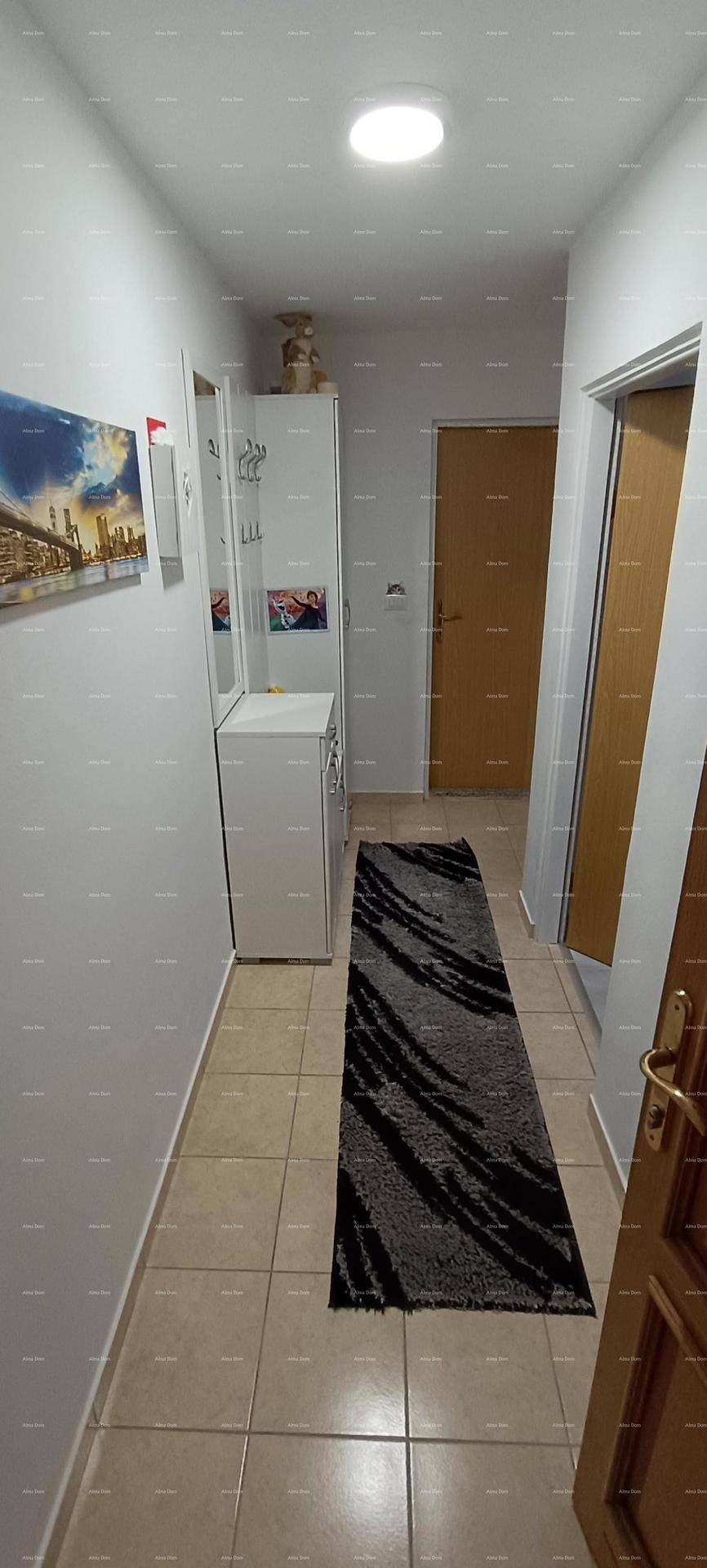 Heller Flur mit Fliesenboden, Garderobe und einem Spiegel, der den Raum optisch vergrößert.