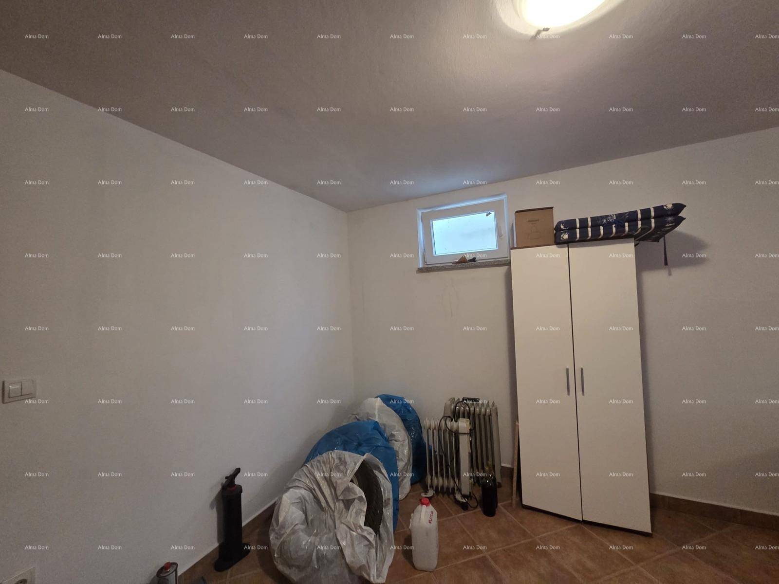 Abstellraum mit Fenster, Schrank und verschiedenen Gegenständen, bietet zusätzlichen Stauraum.