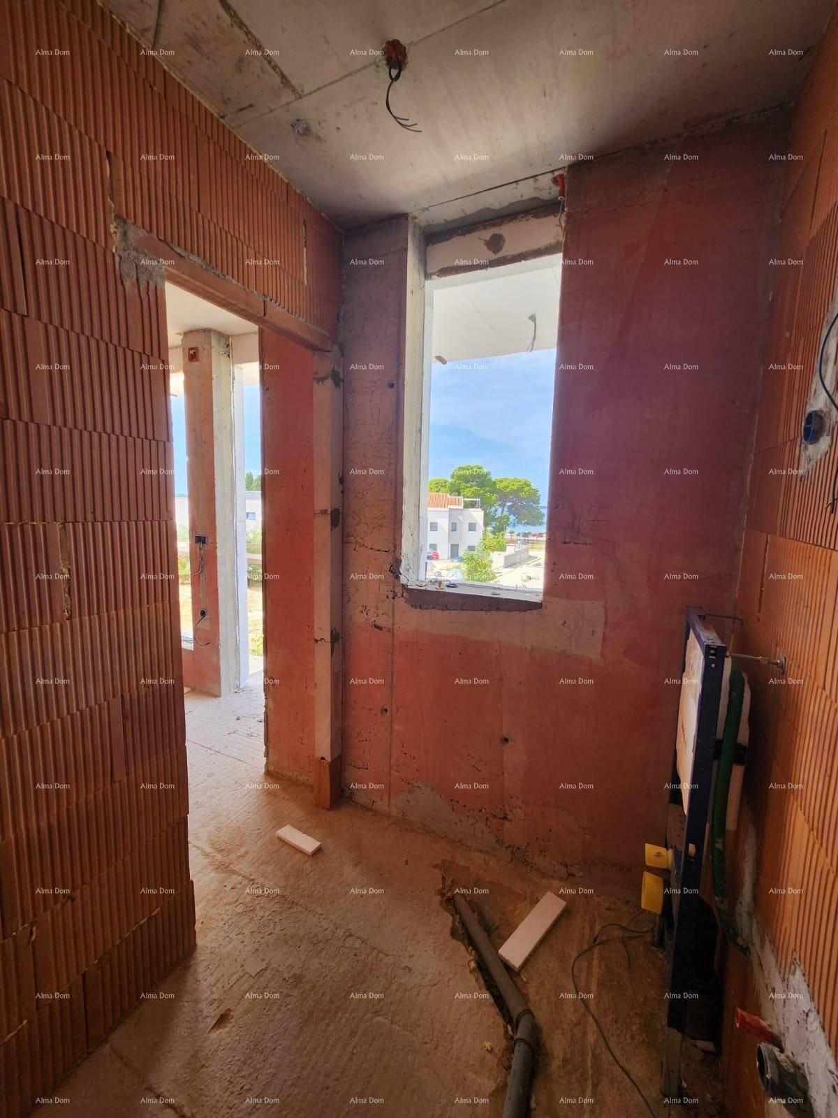 Rohbau eines Raumes mit Ziegelwänden und einem Fenster, das einen Blick auf das Meer bietet.