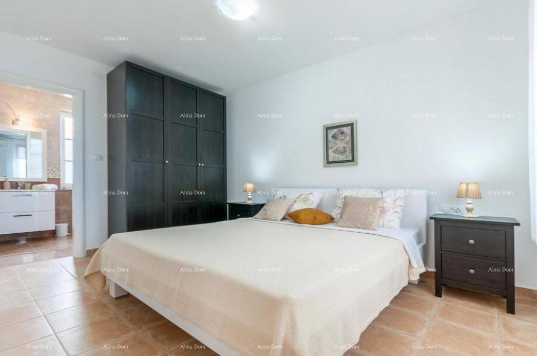 Gemütliches Schlafzimmer mit Doppelbett, dunklem Kleiderschrank und Zugang zu einem weiteren Badezimmer.