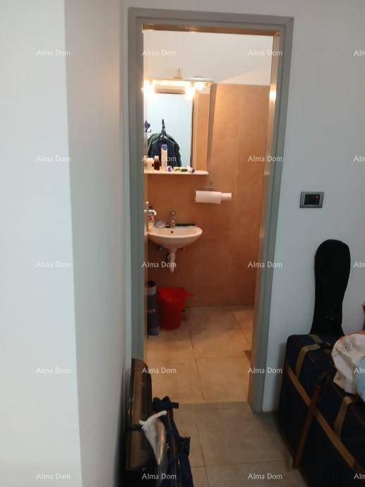 Kleines Badezimmer mit Waschbecken, Spiegel und beigefarbenen Fliesen.