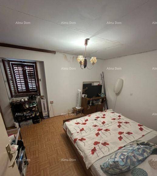 Schlafzimmer mit Parkettboden, Doppelbett und Fenster mit traditionellen Holzläden.