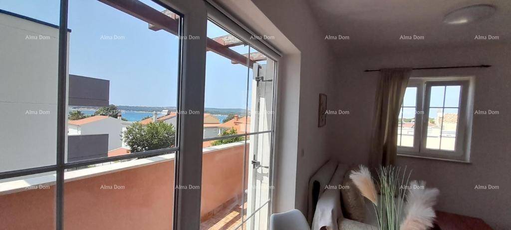 Gemütlicher Wohnbereich mit Fenster und Zugang zum Balkon, bietet einen weiten Meerblick.