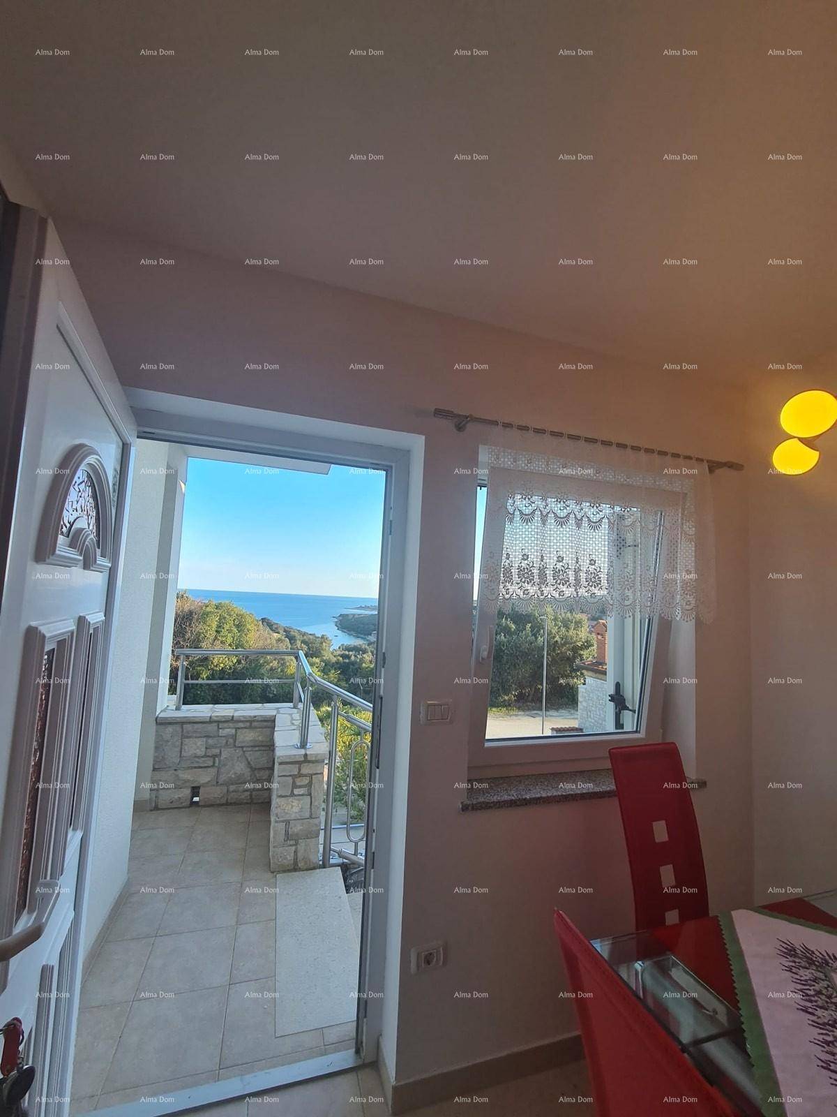 Essbereich mit Meerblick durch die Terrassentür und ein Fenster mit Spitze.