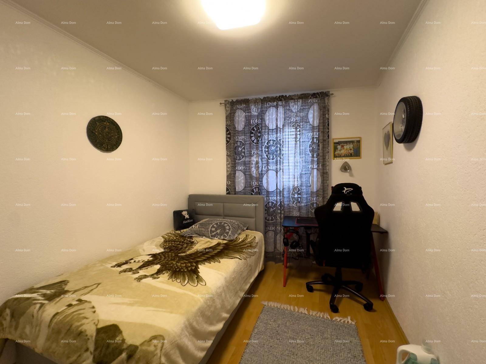 Kinder- oder Gästezimmer mit Einzelbett, Schreibtisch und gemusterten Vorhängen.