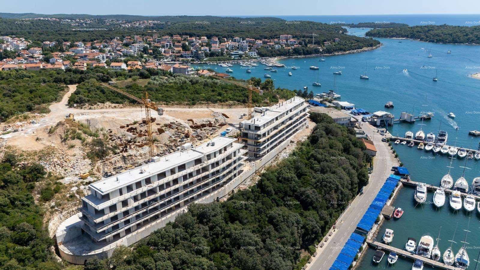 Luftaufnahme der im Bau befindlichen Gebäude mit Blick auf den Yachthafen und die Küstenlandschaft.