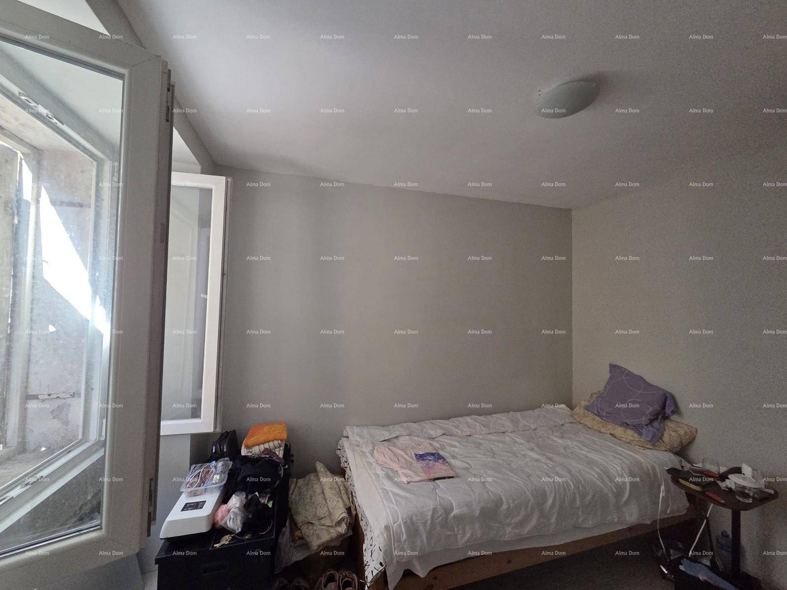 Schlafzimmer mit einem Bett, einem offenen Fenster und einfacher, funktionaler Einrichtung.