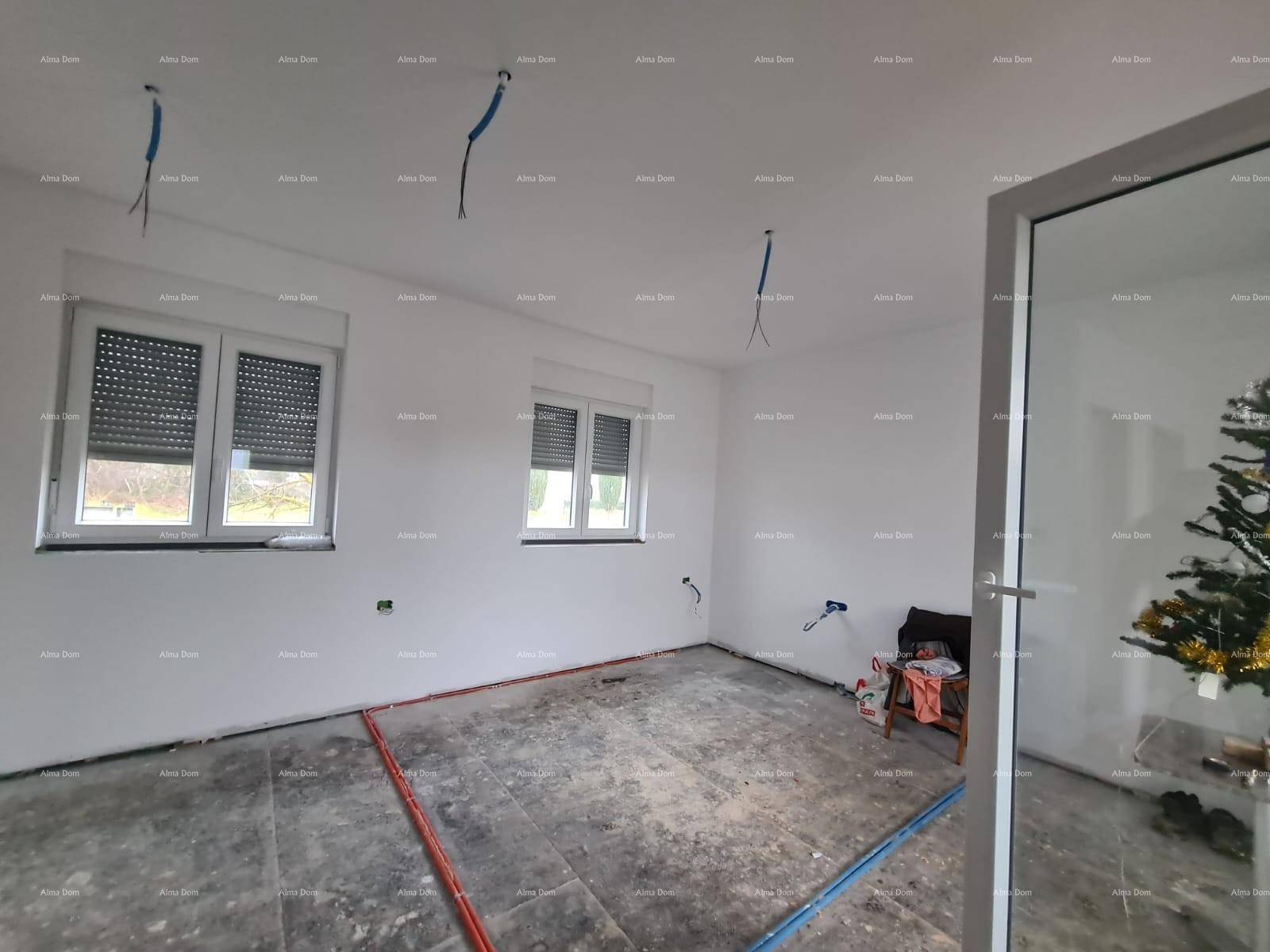 Geräumiger Rohbau-Innenraum mit zwei Fenstern, sichtbaren Leitungen und viel natürlichem Licht.