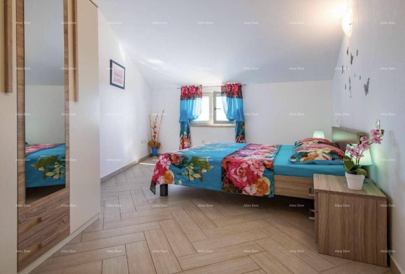Schlafzimmer im Dachgeschoss mit Holzboden, Fenster und Spiegelschrank.