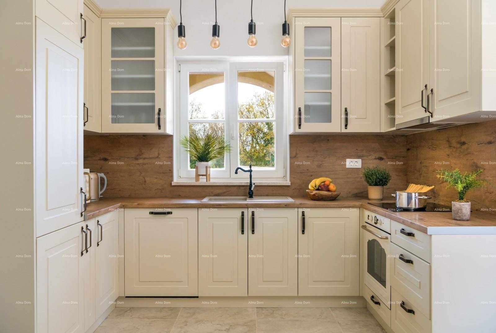 Helle Küche im Landhausstil mit Holztheke, modernen Geräten und Fensterblick.