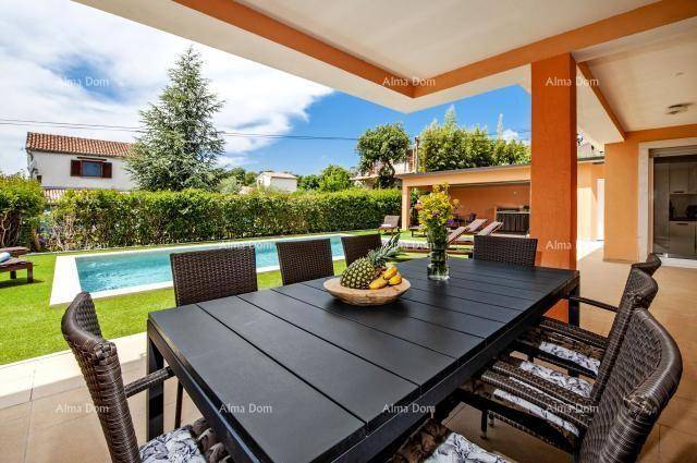 Gemütlicher Essbereich im Freien mit großem Tisch und Blick auf den Pool und Garten.