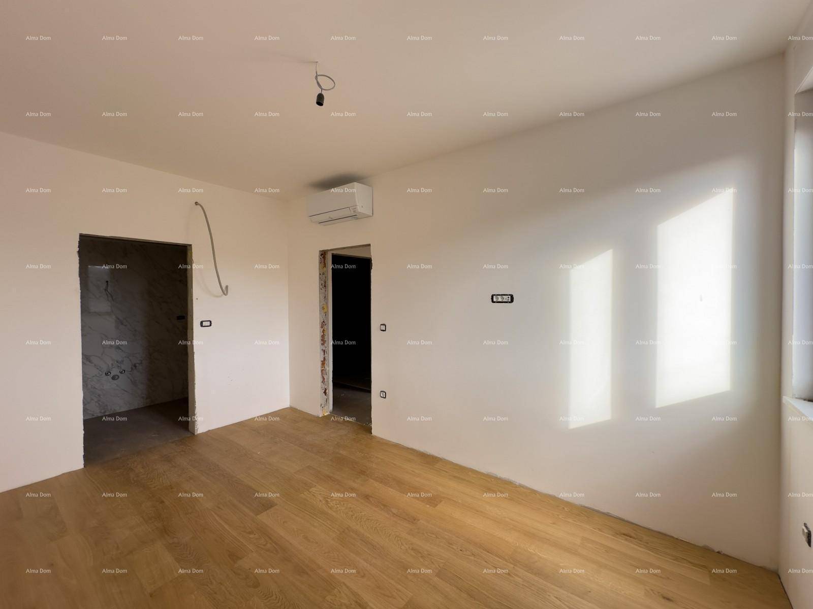 Heller, unmöblierter Raum in einem Neubau mit Holzboden und Klimaanlage.