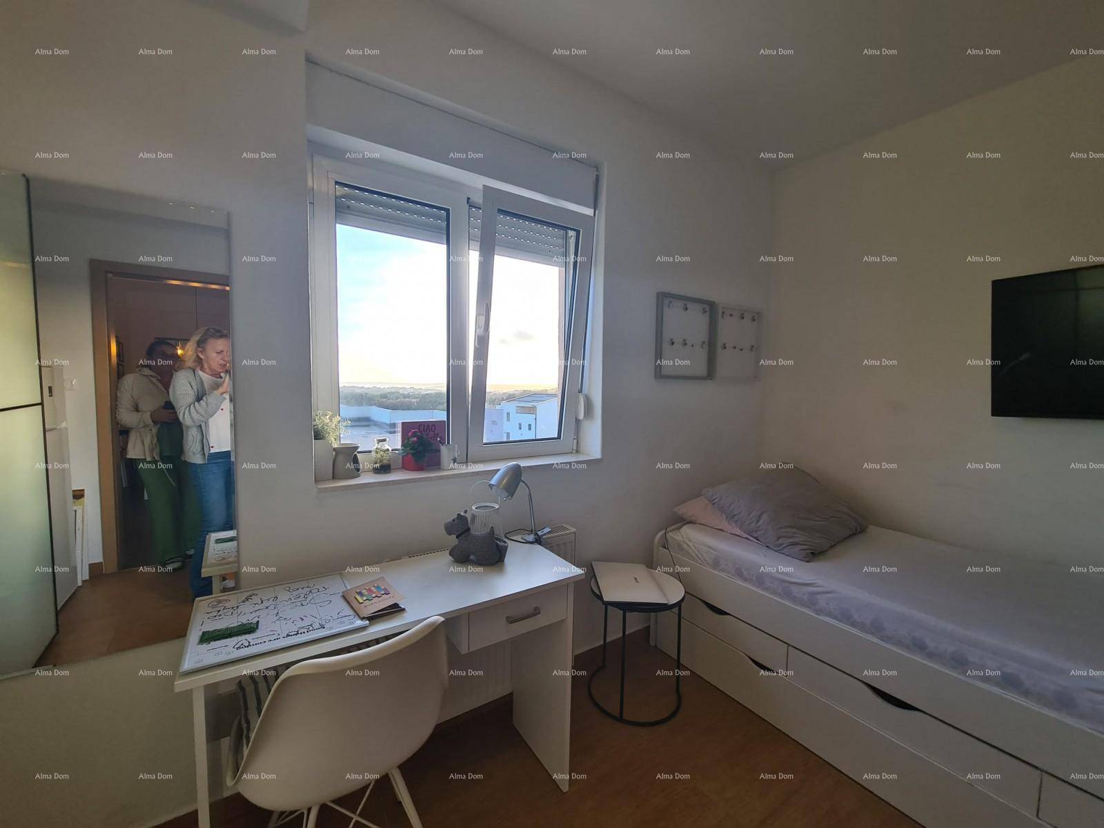 Helles Schlafzimmer mit Schreibtisch, großem Fenster und Blick in die Ferne.