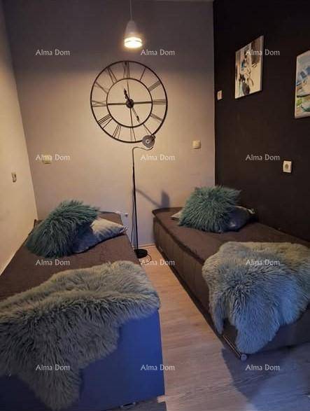 Gemütliches Schlafzimmer mit zwei Einzelbetten, dunkler Wand und großer Wanduhr.