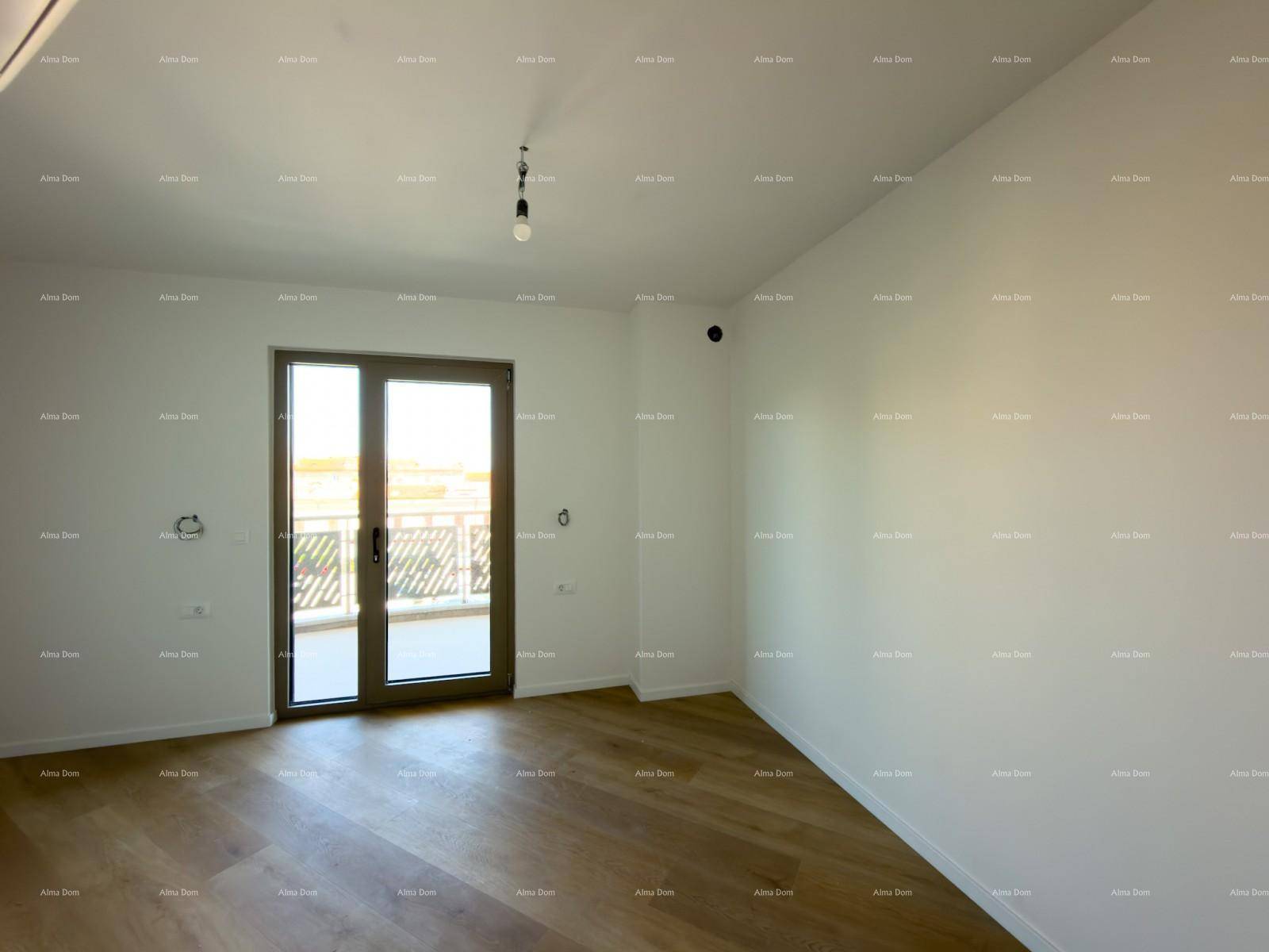 Leerer Raum mit Holzboden und großem Glaszugang zu einem Balkon.