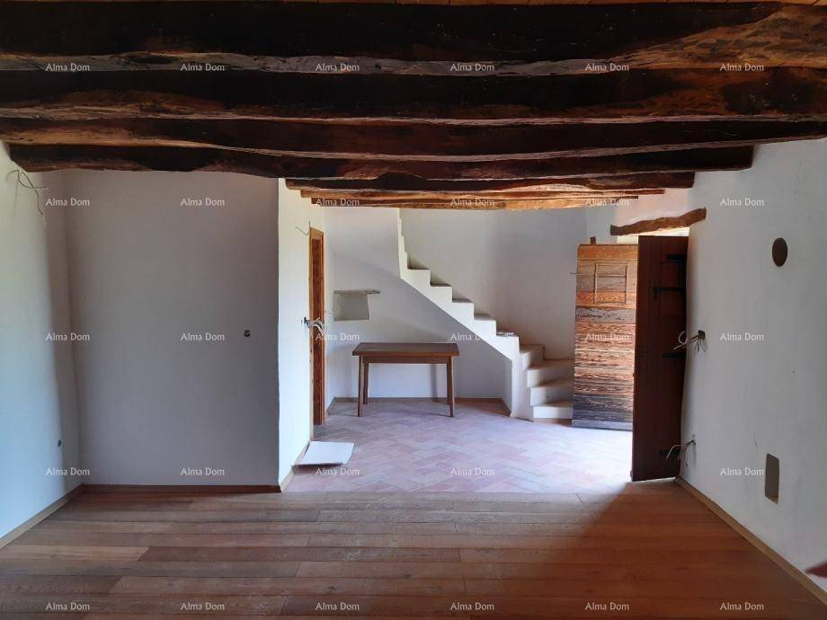 Offener Innenraum mit Treppe, Holzbalken und gemischtem Bodenbelag, bereit zum Ausbau.