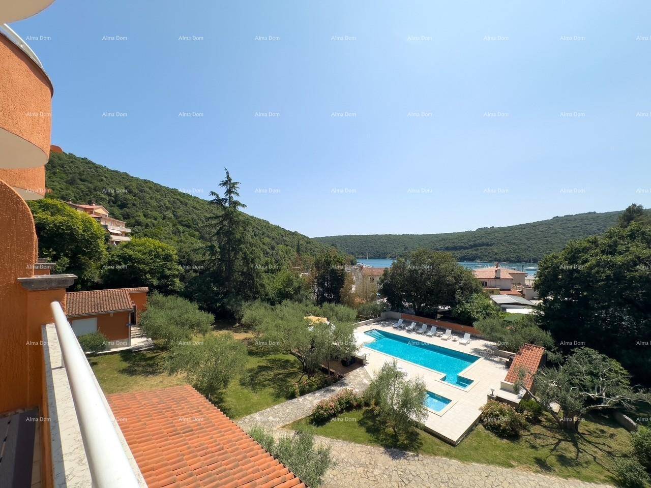 Balkon mit weitem Blick über den Pool, die grüne Landschaft und die Bucht mit dem Meer.