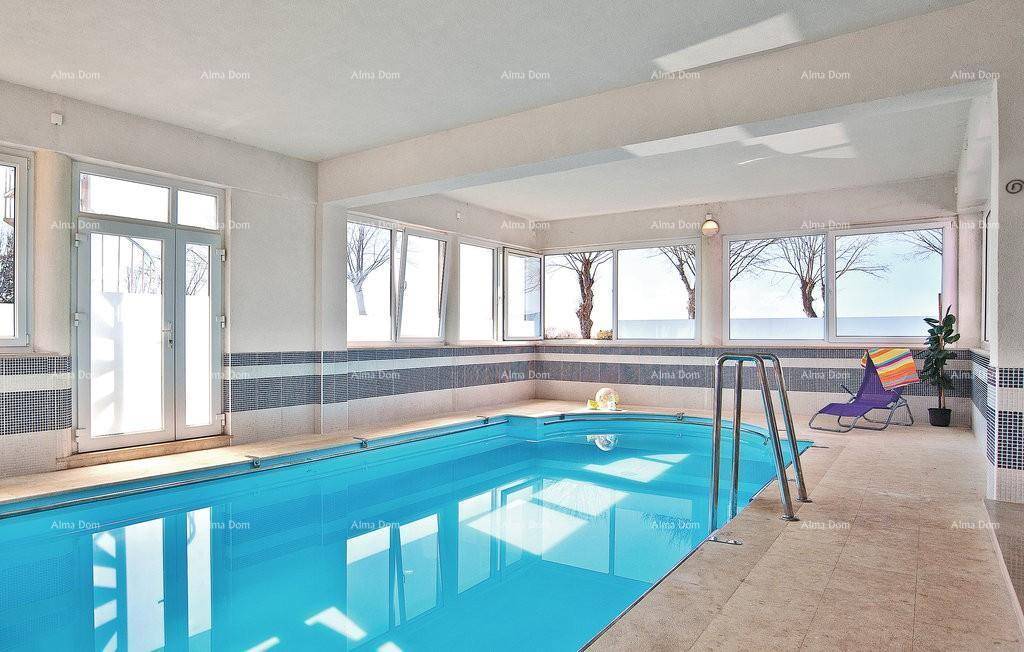 Heller Innenpool mit großen Fenstern und Zugang zum Außenbereich.