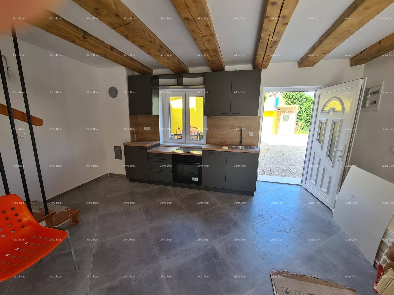 Neue Küche mit grauen Schränken, Holzarbeitsplatten und sichtbaren Deckenbalken.