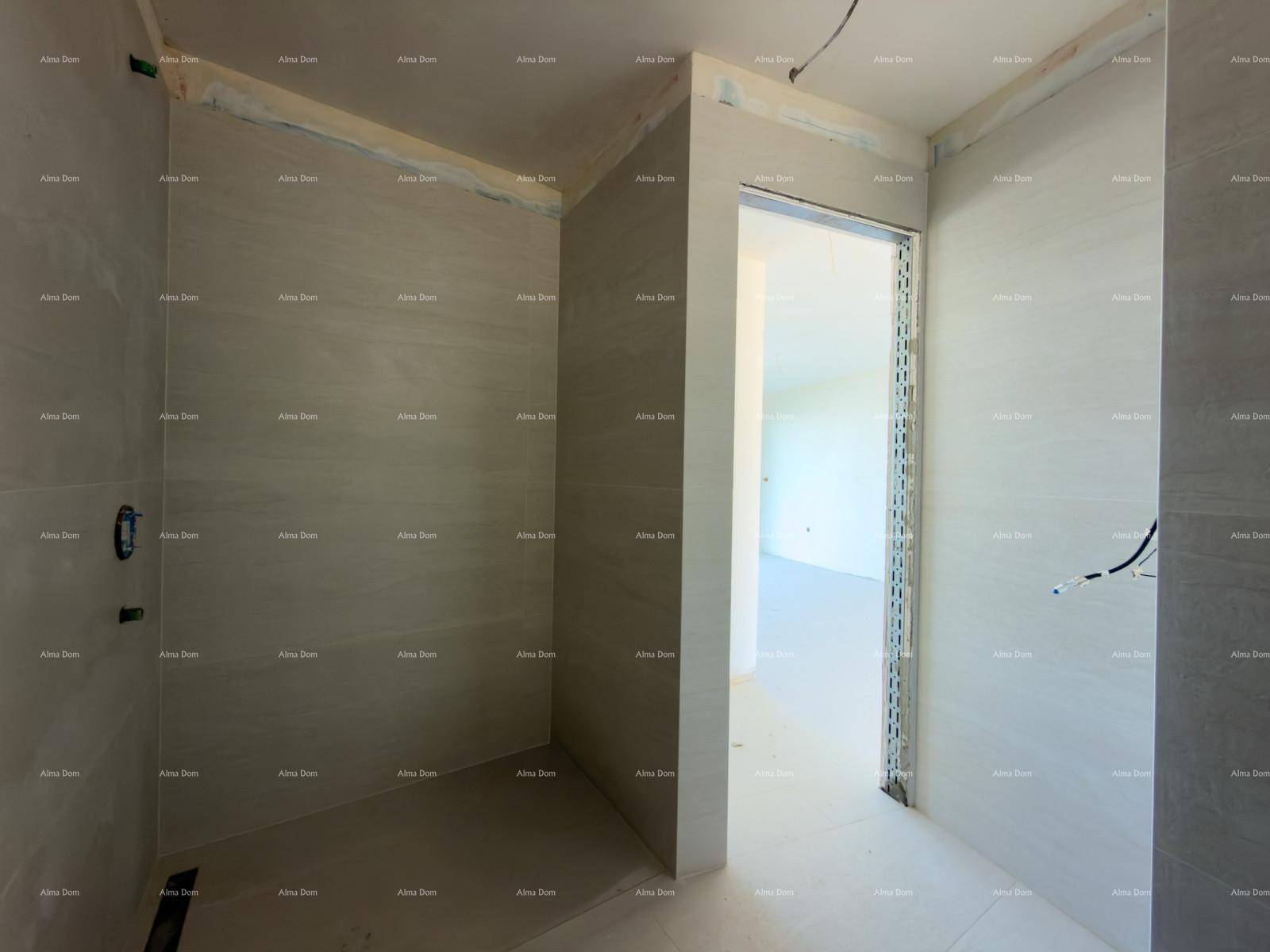 Unfertiges Badezimmer mit grauen Fliesen und vorbereiteter Duschfläche, bereit für den Ausbau.