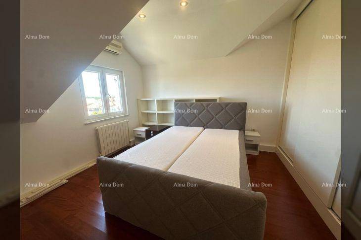 Schlafzimmer im Dachgeschoss mit Doppelbett, Holzboden und Einbauregal.