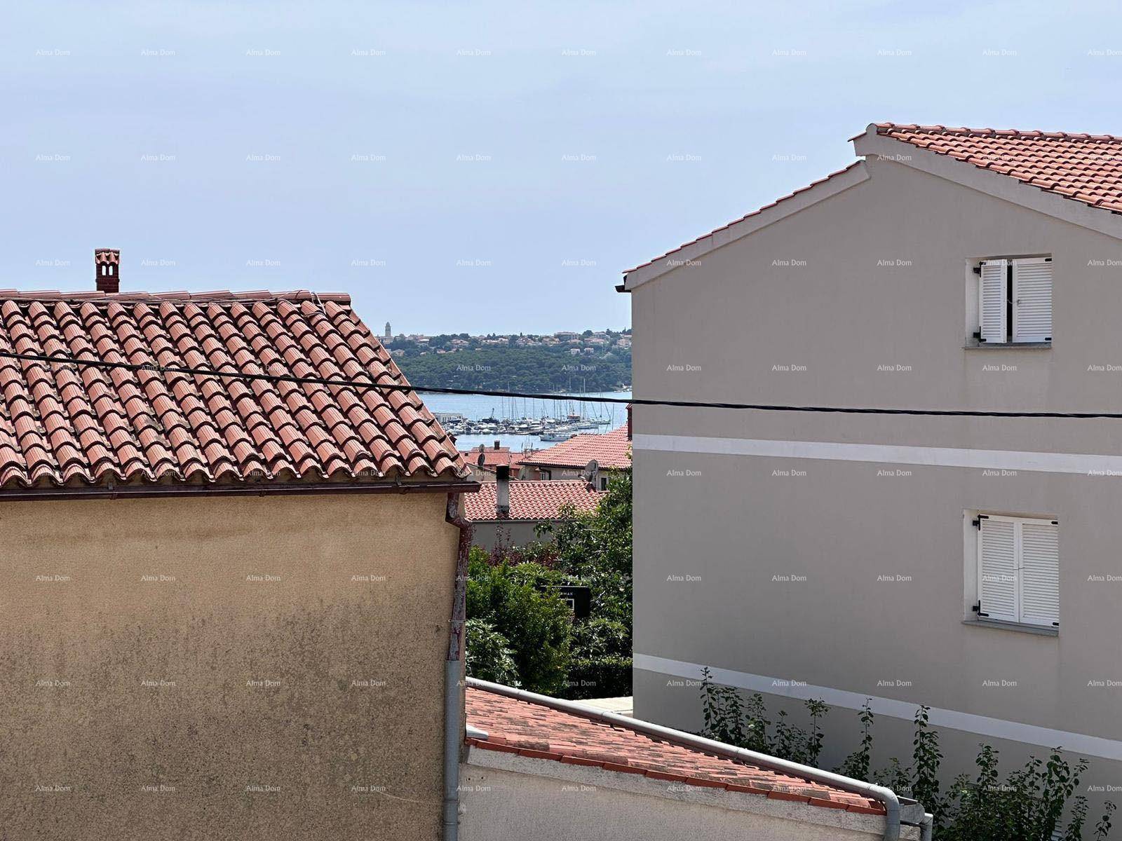 Panoramablick über rote Ziegeldächer auf das weite Meer und den belebten Hafen in der Ferne.