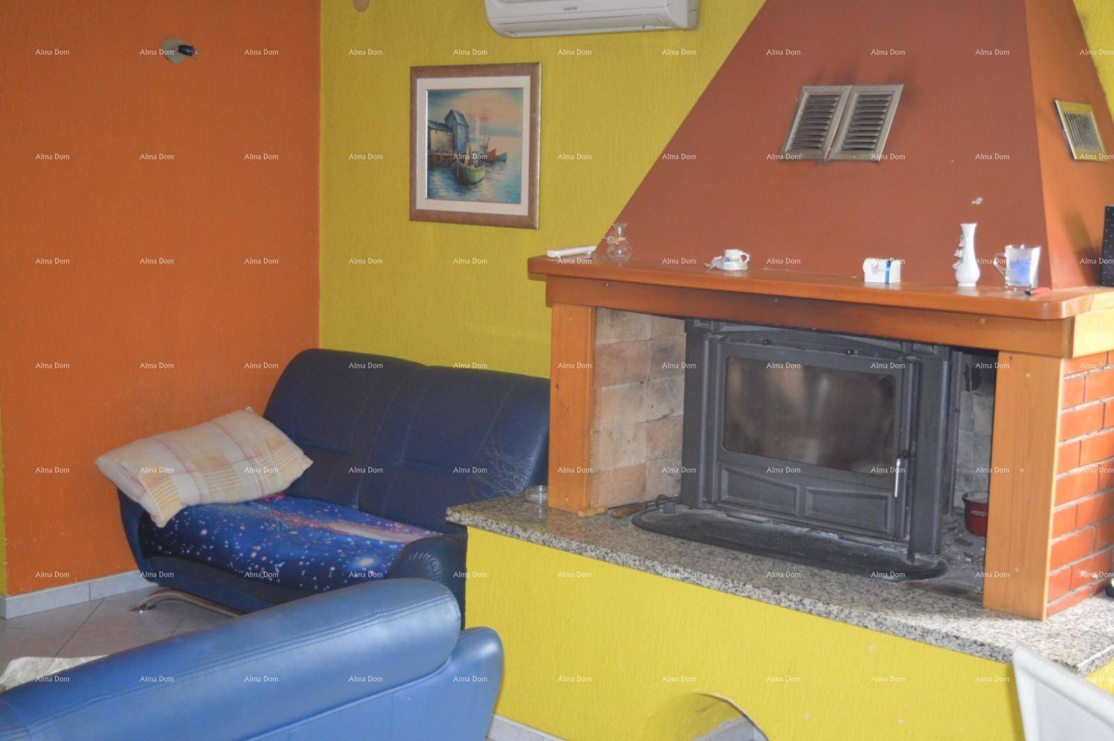 Gemütliches Wohnzimmer mit Kamin, blauer Couch und lebhaften gelb-orangen Wänden.