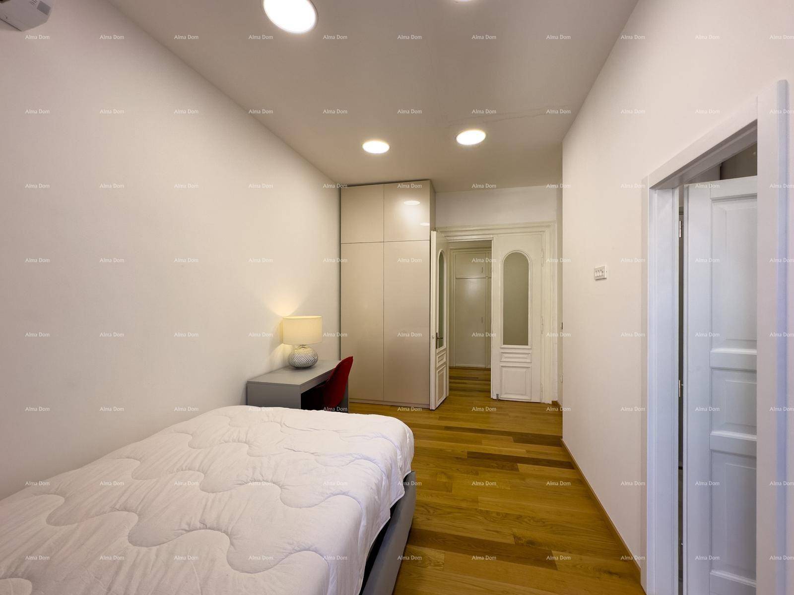 Schlafzimmer mit Holzboden, Schreibtisch und Kleiderschrank, mit Zugang zu einem weiteren Raum.